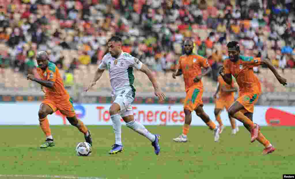 Algeria&#39;s Youcef Belaili in action with Ivory Coast&#39;s Jean Michael Seri and Ibrahim Sangare in Cameroon on Jan. 20, 2022.