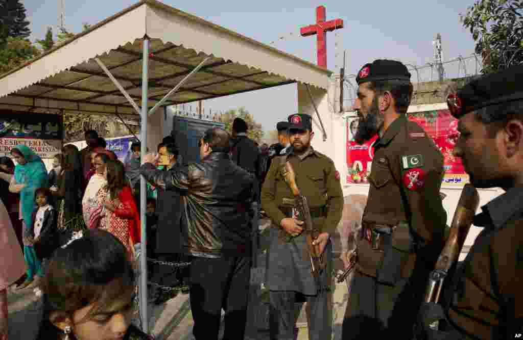 Pakistani paramilitary officers and policemen are on alert as Pakistani Christians leave a church after attending the Christmas mass at a church in Islamabad, Dec. 25, 2016.