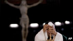 Un sacerdote bendice el pan y el vino durante una misa en una iglesia de Caracas Venezuela. Mayo 29, 2013.