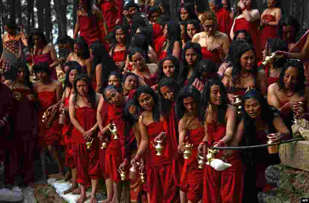Hindu devotees prepare to take part in a mass bathing ritual during the month-long Swasthani Festival in Changu Narayan at Bhaktapur, on the outskirts of Kathmandu, Nepal.