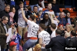 Protesters are escorted out of UIC Pavilion before Republican U.S. presidential candidate Donald Trump's rally at the University of Illinois at Chicago, March 11, 2016.