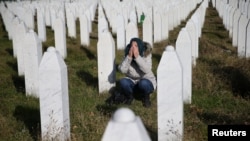 FILE - A woman reacts near a grave of her family members in the Memorial center Potocari near Srebrenica, Bosnia and Herzegovina, after the court proceedings of former Bosnian Serb general Ratko Mladic, Nov. 22, 2017. 
