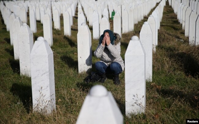 A woman reacts near a grave of her family members in the Memorial centre Potocari near Srebrenica, Bosnia and Herzegovina, after the court proceedings of former Bosnian Serb general Ratko Mladic, Nov. 22, 2017.