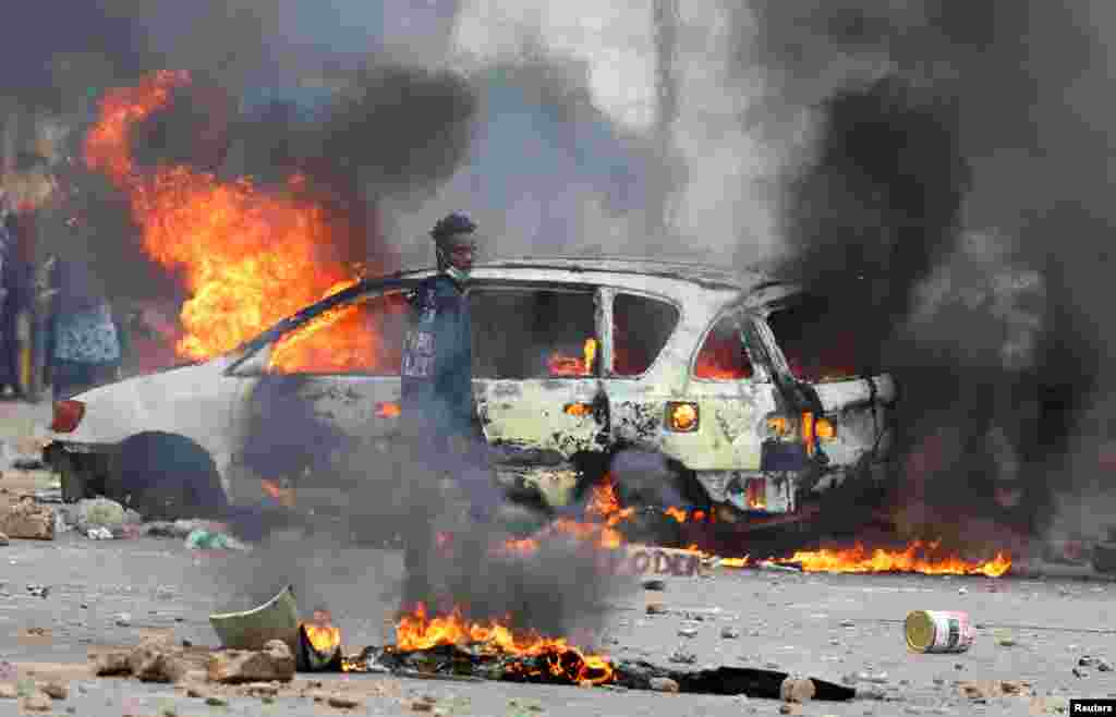 A protester looks on near a burning barricade during a &quot;national shutdown&quot; against the election outcome, in Maputo, Mozambique, Nov. 7, 2024.