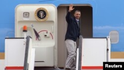 U.S. President Barack Obama waves as he boards Air Force One at the airport in Amman March 23, 2013. 