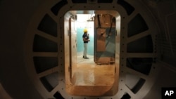 FILE - A worker stands at the entrance of a reactor at the Bushehr nuclear power plant, in Bushehr, Iran, Aug. 22, 2010. U.S. President Donald Trump says he wants more stringent monitoring of the impementation of a nuclear deal with Iran.