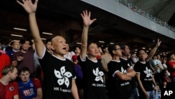 在香港举行的2022年卡塔尔世界杯和2023年亚足联亚洲杯预选赛第二轮香港对阵伊朗的比赛中，香港球迷身穿印有香港国旗黑色图案的T恤抗议政府。(2019年9月10日)