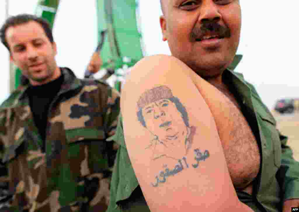 March 16: A Libyan government soldier displays a tattoo of Muammar Gaddafi at the west gate of town Ajdabiyah. (Reuters)