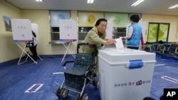 A woman casts her ballot for presidential election at a polling station in Seoul, South Korea, May 9, 2017.