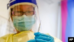 A physician assistant prepares a syringe with the monkeypox vaccine for a patient during a vaccination clinic Friday, Aug. 19, 2022, in New York. 