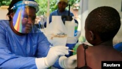 우간다 보건 종사자가 어린이에게 에볼라 바이러스 백신을 접종하고 있다. (자료사진)