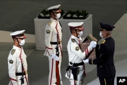 Color guards carry the remains of former Prime Minister of Japan Shinzo Abe during the state funeral Tuesday Sept. 27, 2022, at Nippon Budokan in Tokyo. (AP Photo/Eugene Hoshiko, Pool)