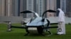 A man looks at the XPeng X2, an electric flying taxi developed by the Guangzhou-based XPeng, Inc's aviation affiliate, being tested in front of the Marina District in Dubai, United Arab Emirates, Oct. 10, 2022.