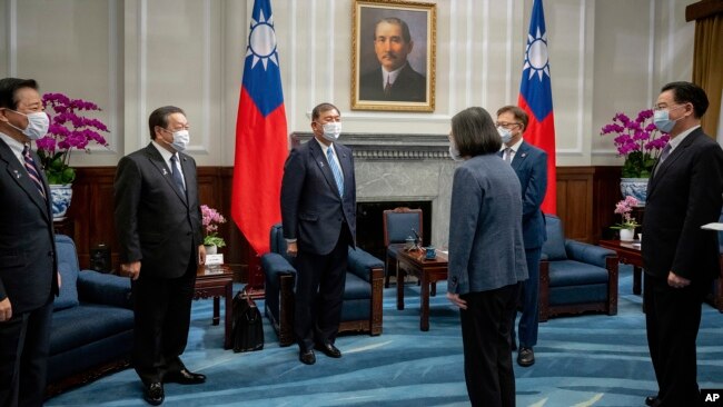 In this photo released by the Taiwan Presidential Office, Taiwan's President Tsai Ing-wen, third right, greets Japanese delegation led by lawmaker and former Defense Minister Shigeru Ishiba at the presidential office in Taipei, Taiwan, July 28, 2022.