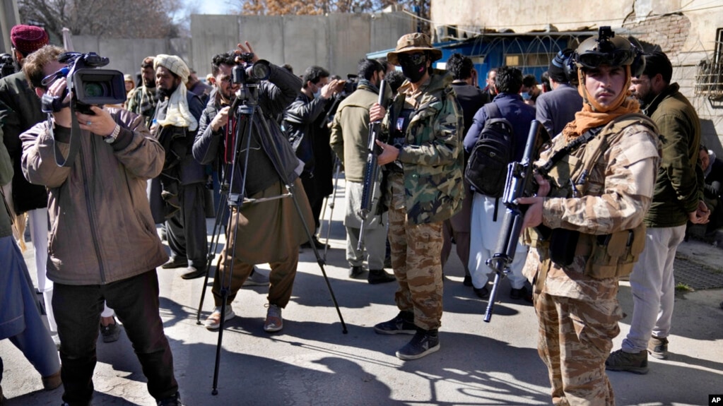 FILE - Afghan cameramen cover a protest against US President Joe Biden in Kabul, Afghanistan, Feb. 15, 2022. 