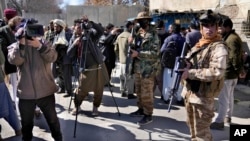 FILE - Afghan cameramen cover a protest against US President Joe Biden in Kabul, Afghanistan, Feb. 15, 2022. 