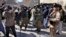 FILE - Afghan cameramen cover a protest against US President Joe Biden in Kabul, Afghanistan, Feb. 15, 2022. 