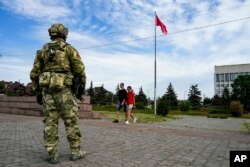 资料照：一名俄罗斯士兵在乌克兰南部赫尔松州的一处纪念广场上站岗。（2022年5月20日）