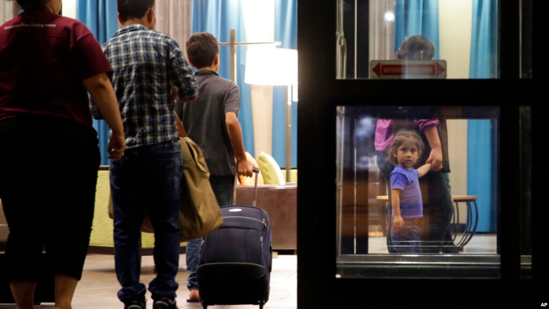 ARCHIVO - Inmigrantes que solicitan asilo y que fueron reunidos tras haber sido separados llegan a un hotel, el 23 de julio de 2018, en San Antonio. 
