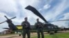 Dos agentes junto a los helicópteros Black Hawk remodelados para la protección del medio ambiente, el 26 de octubre de 2022, en la base de antinarcóticos de la Policía de Colombia, en San José del Guaviare. 