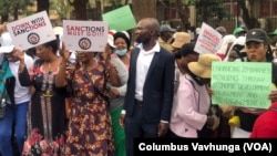 Vamwe vanhu vachiratidzira vachiti zvirango zvibviswe. (Columbus Mavhunga/VOA)