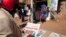 FILE - A man reads newspaper headlines in Sudan's capital, Khartoum, Nov. 8, 2020. 