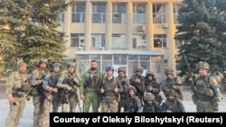 Ukrainian troops pose for a photo in Lyman, Ukraine in this picture released in social media, Oct. 1, 2022.