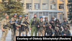 Ukrainian troops pose for a photo in Lyman, Ukraine in this picture released in social media, Oct. 1, 2022.