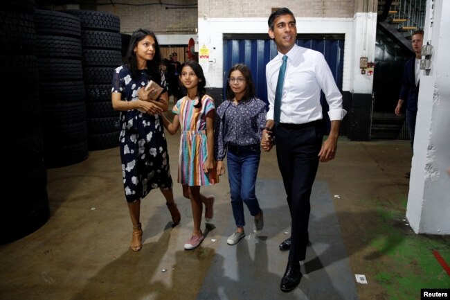 FILE - Rishi Sunak, his wife Akshata Murthy and their daughters Anoushka and Krishna attend a Conservative Party leadership campaign event in Grantham, Britain, July 23, 2022. ( REUTERS/Peter Nicholls )