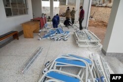 Ugandan Medical staff members assemble beds to be used in the Ebola treatment isolation unit at Mubende regional referral hospital in Uganda, Sept. 24, 2022.