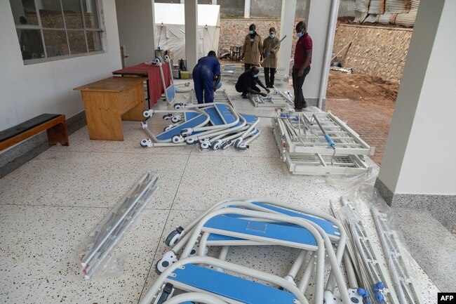 Ugandan Medical staff members assemble beds to be used in the Ebola treatment isolation unit at Mubende regional referral hospital in Uganda, Sept. 24, 2022.