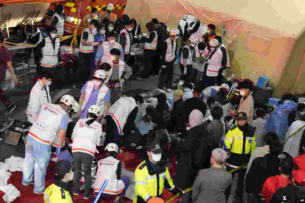 Rescue workers treat injured people on the street near the scene in Seoul, South Korea, Oct. 30, 2022.