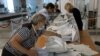 Members of an electoral commission empty a ballot box at a polling station following a referendum on the joining of Russian-controlled regions of Ukraine to Russia, in Sevastopol, Crimea, Sept. 27, 2022. 