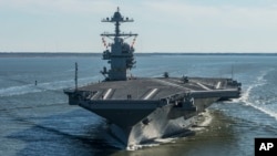 FILE - In this April 8, 2017 photo provided by the U.S. Navy, the USS Gerald R. Ford embarks on the first of its sea trials to test various state-of-the-art systems on its own power for the first time, from Newport News, Va.