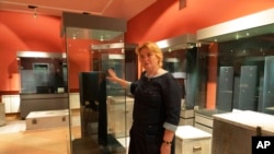 Natalia Panchenko, director of the Museum of Historical Treasures of Ukraine, shows empty showcases in Kyiv, Ukraine, Sept. 2, 2022.