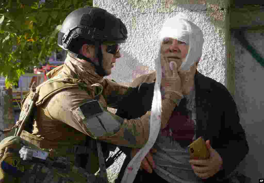 An injured woman receives medical treatment at the scene of Russian shelling, in Kyiv, Ukraine, Oct. 10, 2022.&nbsp;Multiple explosions rocked Kyiv following months of relative calm in the Ukrainian capital.