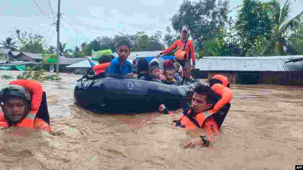 Rescue workers evacuating people from a flooded area due to heavy rain brought by Tropical Storm Nalgae in Parang, Maguindanao province, Philippines. (AFP Photo/Philippine Coast Guard)