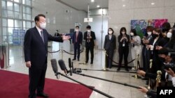 윤석열(왼쪽) 한국 대통령이 용산 대통령실 청사 출근 길에 기자들 질문에 답하고 있다. (자료사진)