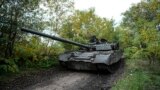 Ukrainian servicemen drive a T-80 tank that they said had been captured from the Russian army, in Bakhmut, Ukraine, Oct. 2, 2022. 