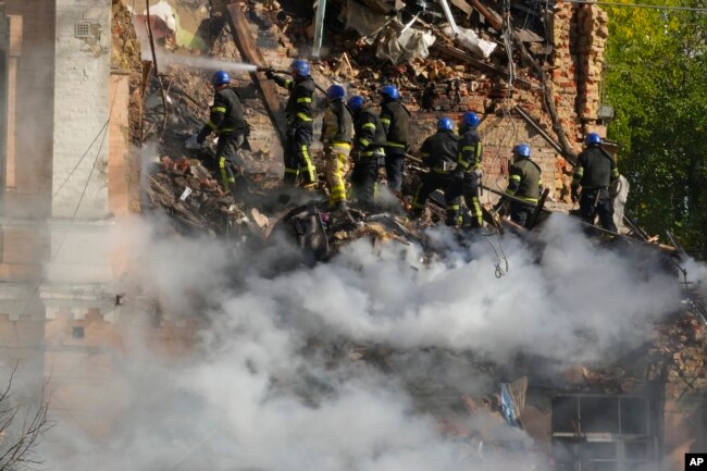 Firefighters try to extinguish a fire after a drone fired at buildings in Kyiv, Ukraine, Monday, Oct. 17, 2022. (AP Photo/Efrem Lukatsky)