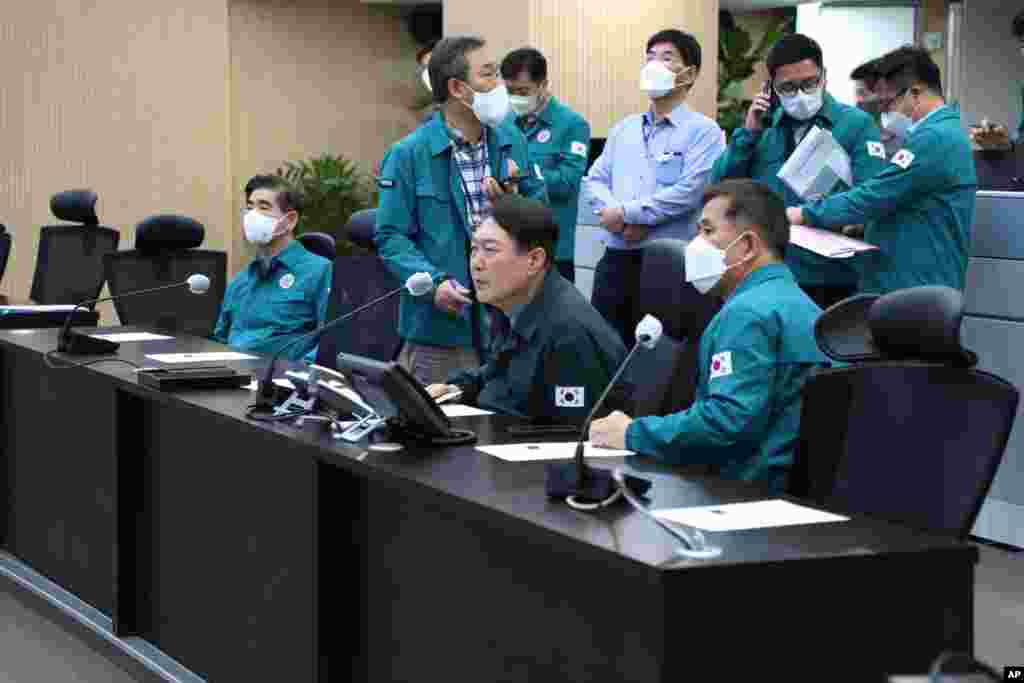 In this photo provided by the South Korean Presidential Office, President Yoon Suk Yeol, center, attends an emergency meeting at the presidential office in South Korea, Oct. 30, 2022.