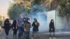 In this Oct. 1, 2022, photo taken by an individual not employed by the Associated Press and obtained by the AP outside Iran, tear gas is fired by security forces to disperse protesters in front of Tehran University, in Tehran, Iran.
