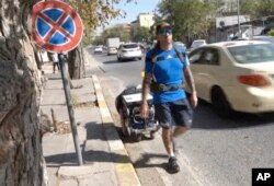 Dalam gambar yang diambil dari video ini, Santiago Sánchez (41 tahun), mendokumentasikan perjalanannya dengan berjalan kaki dari Madrid ke Doha untuk menghadiri Piala Dunia FIFA 2022 setibanya di Sulaymaniyah, Irak, 9 September 2022. (AP)