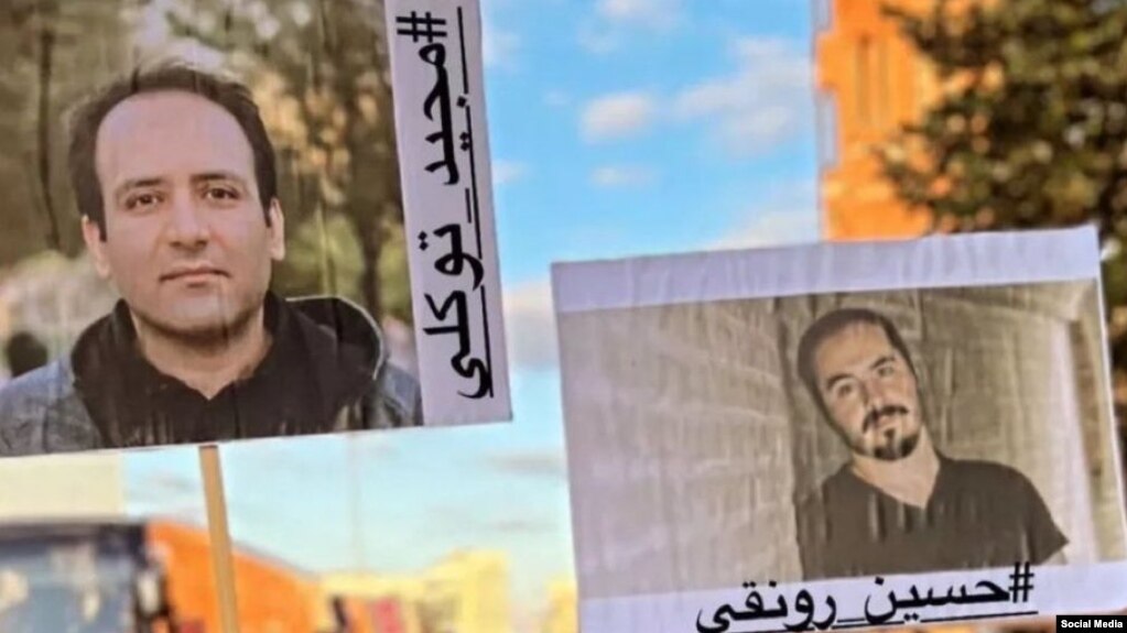 تصاویر حسین رونقی و مجید توکلی در دست یکی از تظاهرکنندگان ۱ اکتبر