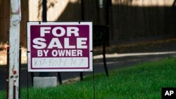 FILE - A 'for sale by owner' sign is displayed outside home in Northbrook, Ill., Sept. 21, 2022. 