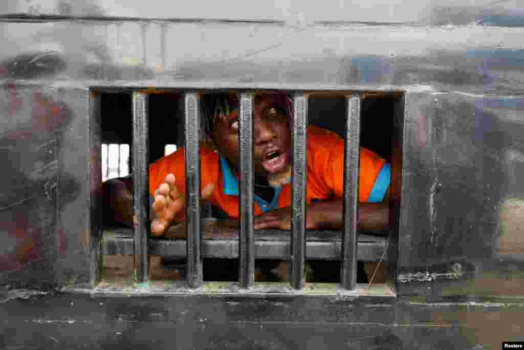 A demonstrator reacts as he is detained in a police van during a rally on the second anniversary of anti-police brutality protests that investigators said ended when security forces fired live rounds into the crowd at the Lekki toll gate, in Lagos, Nigeria.