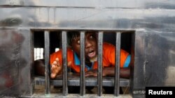 A demonstrator reacts as he is detained in a police van during a rally on the second anniversary of anti-police brutality protests that investigators said ended when security forces fired live rounds into the crowd at the Lekki toll gate, in Lagos, Nigeria.