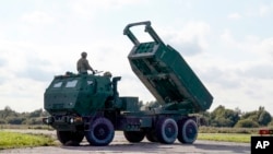 FILE - A High-Mobility Artillery Rocket System (HIMARS ) in operation during military exercises at Spilve Airport in Riga, Latvia, Sept. 26, 2022. 