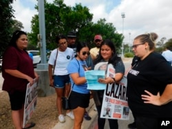 Parents who lost children in the Robb Elementary School shooting look at a sample ballot before going to vote on Monday, Oct. 24, 2022, in Uvalde, Texas.