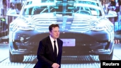 ARCHIVO - El CEO de Tesla Inc, Elon Musk, camina junto a una pantalla que muestra una imagen del automóvil Tesla Model 3 durante una ceremonia de apertura del programa Tesla Model Y fabricado en Shanghái, China, el 7 de enero de 2020.